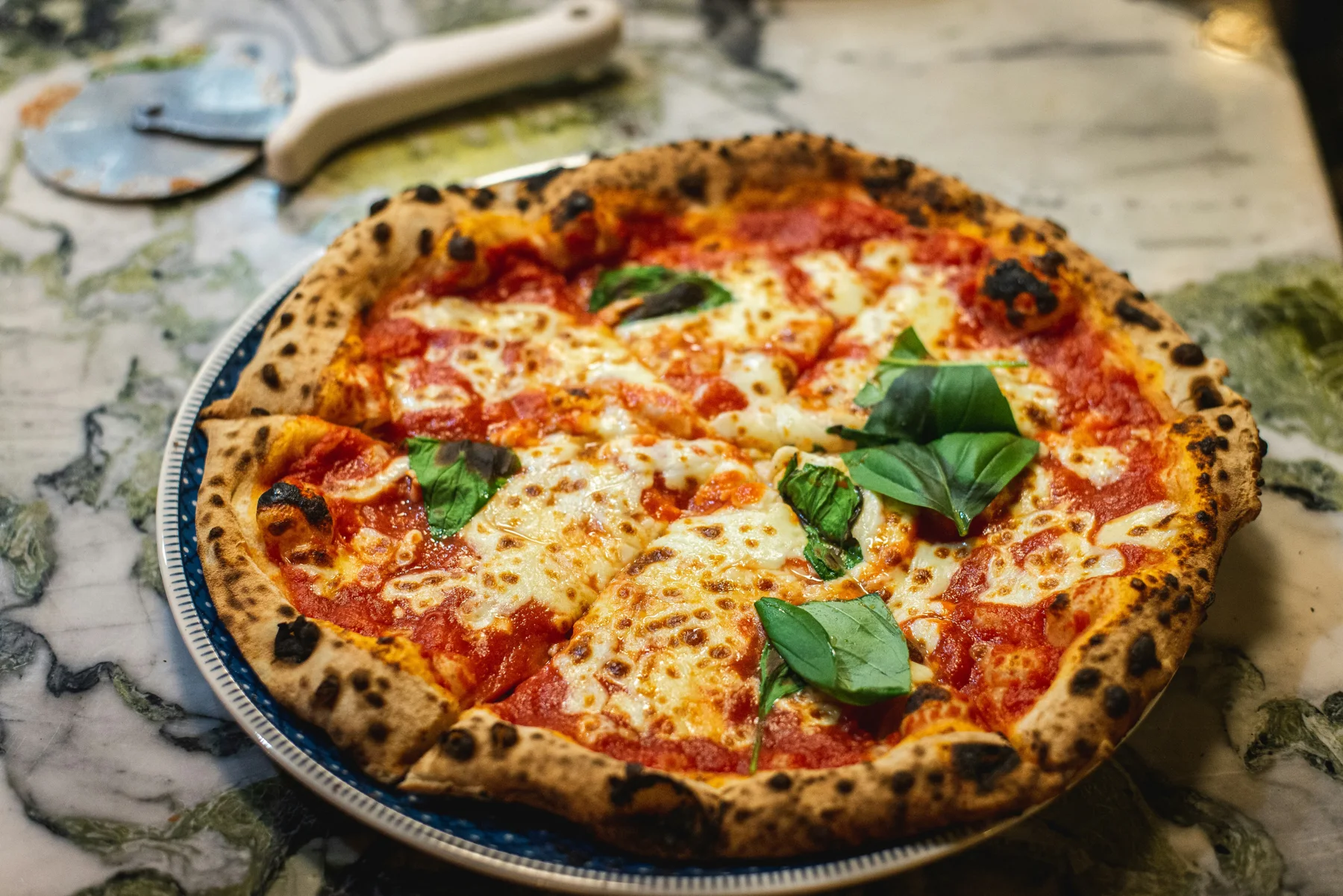 Pizza garnie de tomates et de basilic, photographie d’ambiance